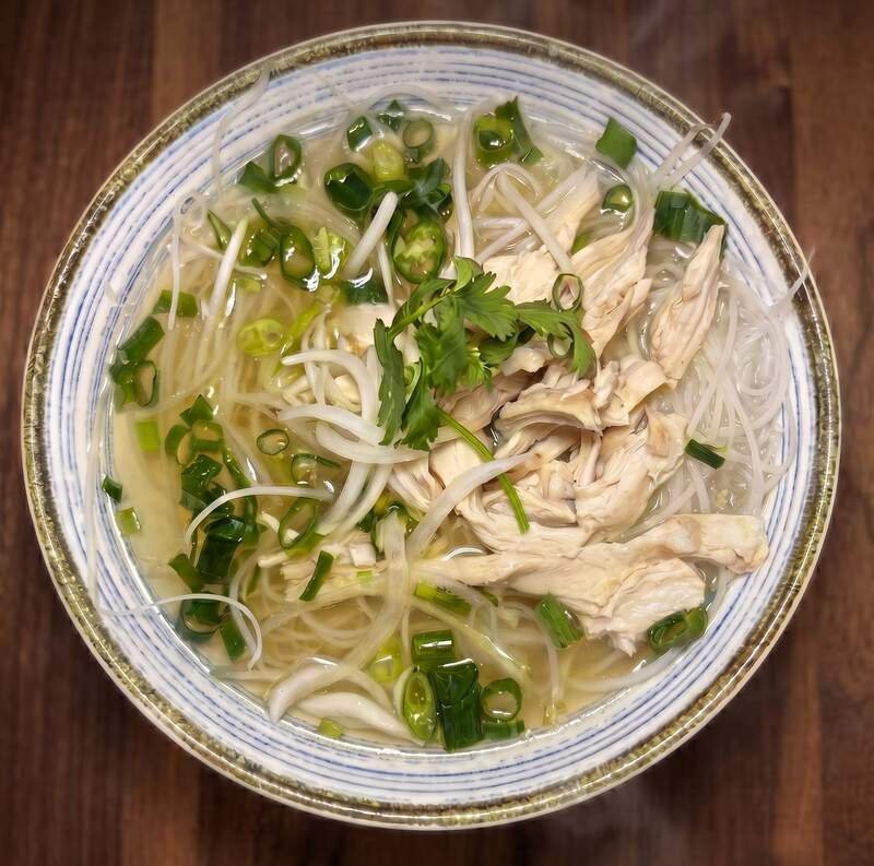 Chicken pho on dark walnut — bean sprouts, scallion, jalapeño, fresh cilantro